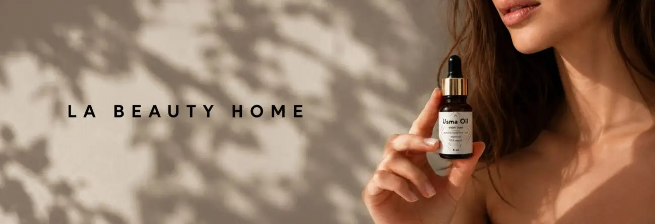 Fragment grafiki La Beauty Home z cieniem rośliny i częściowo widoczną dłonią trzymającą olejek.
